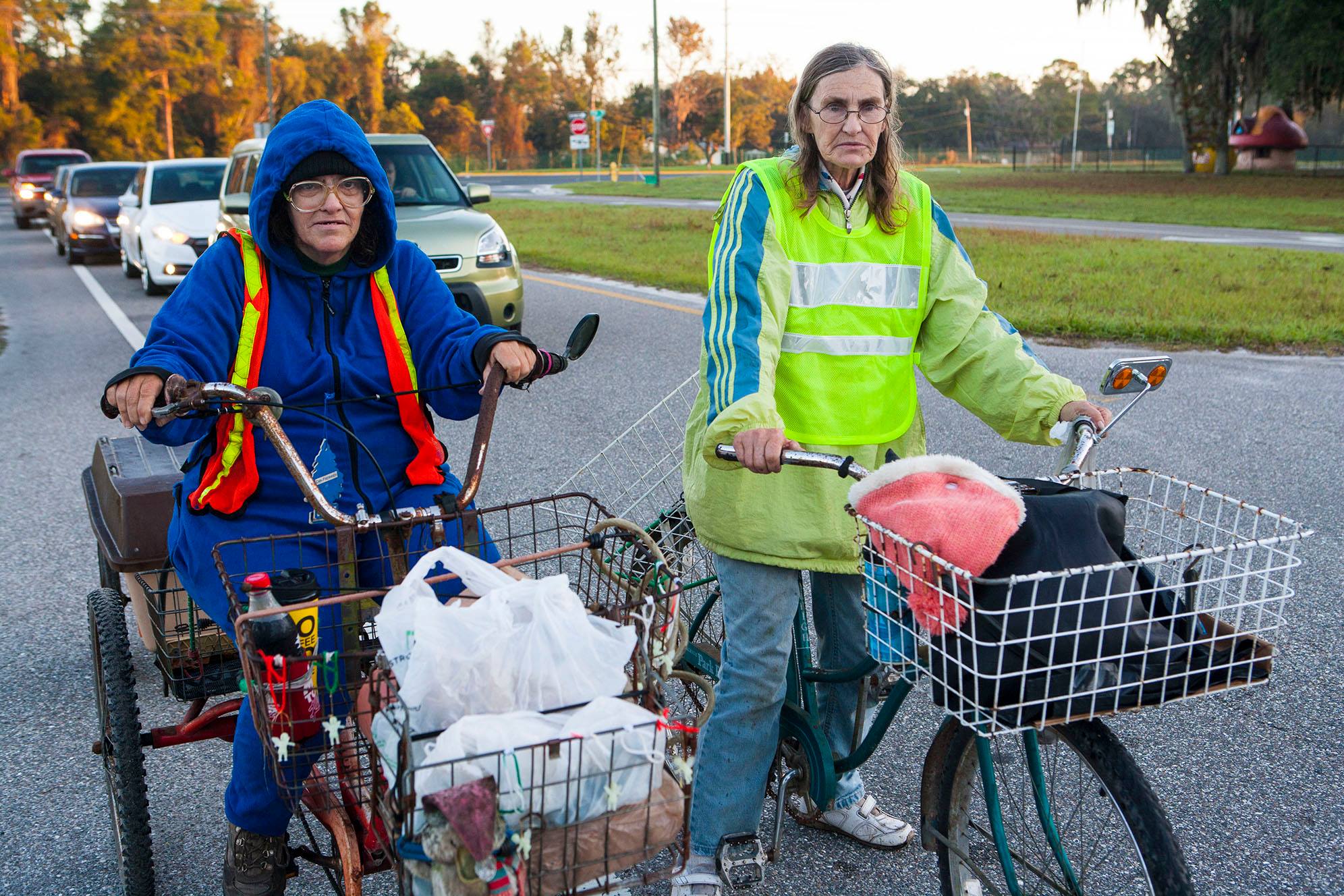 Sisters Cindy Powell, 58, and sixty-two-year old Janet Greil, R, rode their bikes for two hours to reach the 21st Annual Farm Share Holiday Food Giveaway at Faith Baptist Church in New Port Richey. Their car was repossessed and Cindy lost her job at a pig farm. They struggle to afford basic necessities.